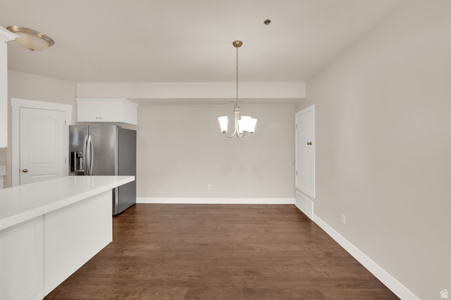 1823 North Crest Road Saratoga Springs, UT 84045 - Photo 7 of 18 Kitchen featuring white cabinets, stainless steel fridge, dark wood finished floors, and suspended lighting