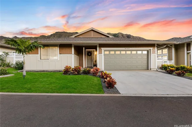 a front view of a house with a garden and yard
