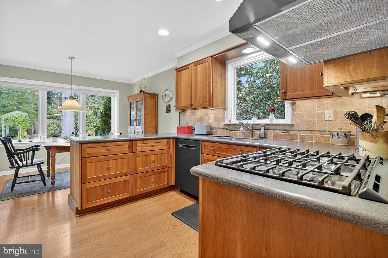 4 Locke Court Ewing, NJ 08628 - Photo 18 of 43 a kitchen with stainless steel appliances granite countertop a stove a sink dishwasher and white cabinets with wooden floor