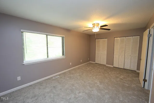 a view of a room with a ceiling fan and a window
