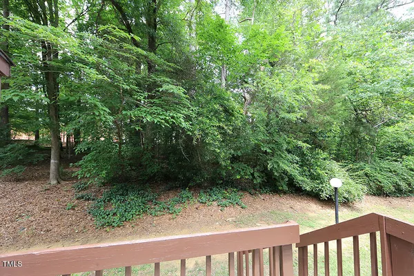 a view of a yard with plants and wooden fence