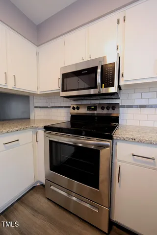 a kitchen with stainless steel appliances a stove microwave and sink