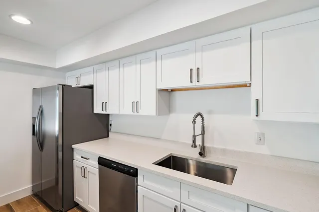 a kitchen with a refrigerator sink and cabinets