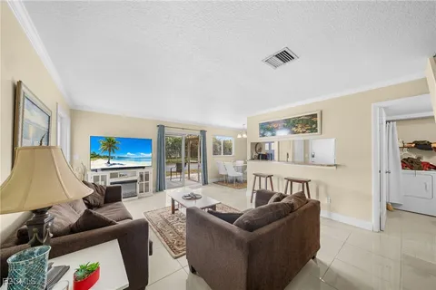 a living room with furniture a flat screen tv and a table