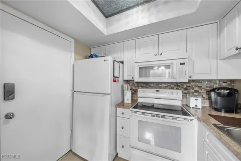 a white refrigerator freezer and a stove sitting inside of a kitchen