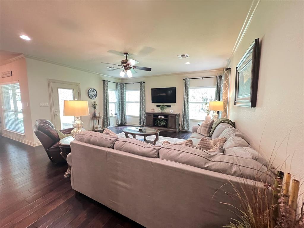 187 Private Road 5987 Yantis, TX 75497 - Photo 16 of 40 Living room with dark hardwood / wood-style floors, ceiling fan, a fireplace, and ornamental molding