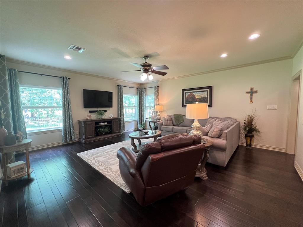 187 Private Road 5987 Yantis, TX 75497 - Photo 20 of 40 Living room featuring a fireplace, ornamental molding, ceiling fan, and dark hardwood / wood-style flooring