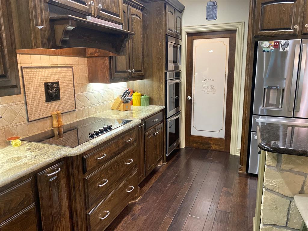187 Private Road 5987 Yantis, TX 75497 - Photo 21 of 40 Kitchen with appliances with stainless steel finishes, tasteful backsplash, dark hardwood / wood-style floors, and dark brown cabinetry