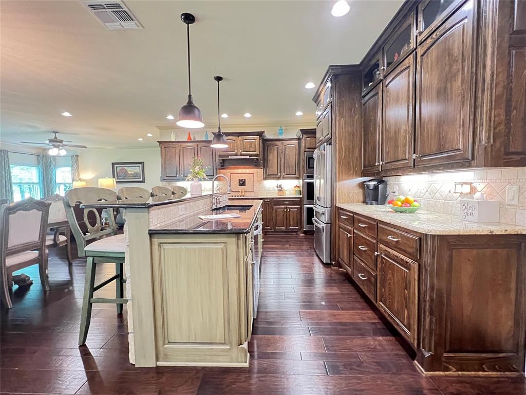 187 Private Road 5987 Yantis, TX 75497 - Photo 23 of 40 Kitchen with dark hardwood / wood-style floors, ceiling fan, pendant lighting, backsplash, and sink