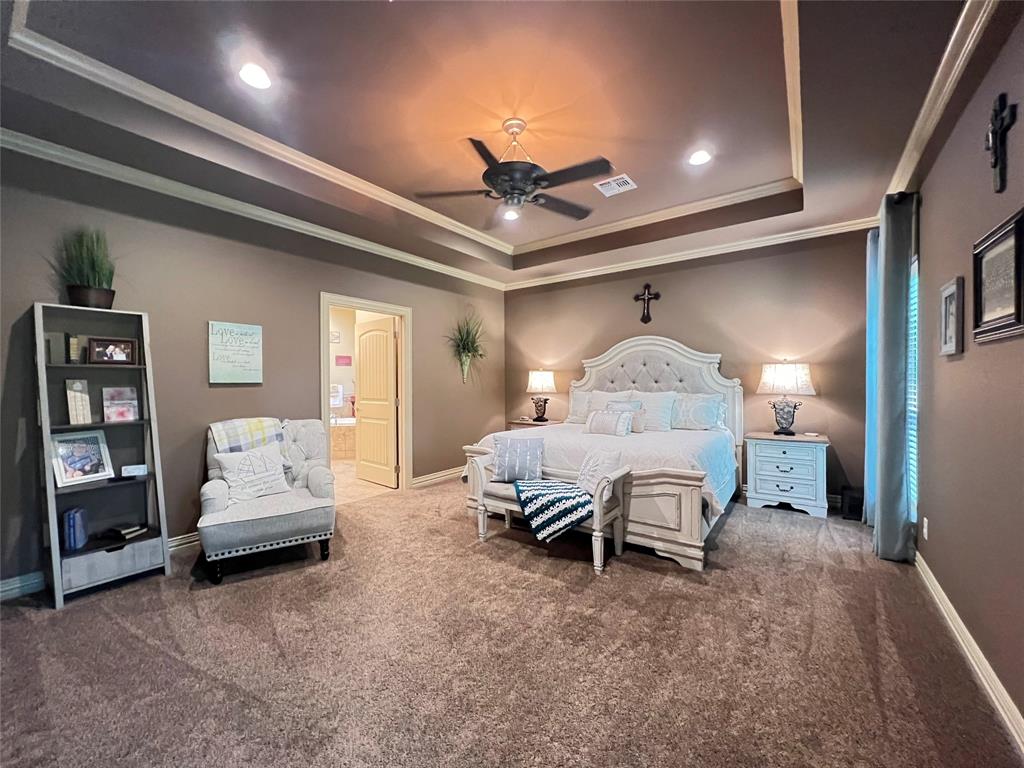 187 Private Road 5987 Yantis, TX 75497 - Photo 28 of 40 Carpeted bedroom with ceiling fan, ensuite bath, a tray ceiling, and crown molding