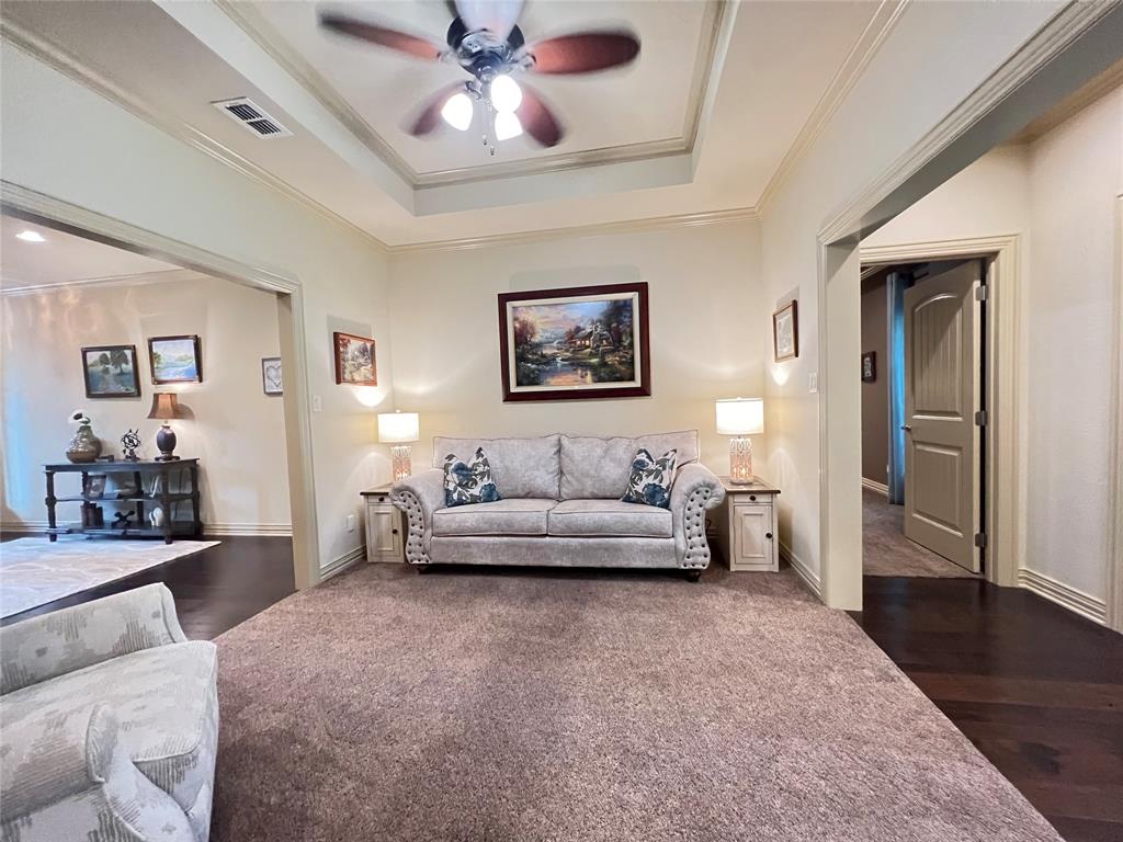 187 Private Road 5987 Yantis, TX 75497 - Photo 9 of 40 Living room with crown molding, ceiling fan, a raised ceiling, and dark hardwood / wood-style flooring