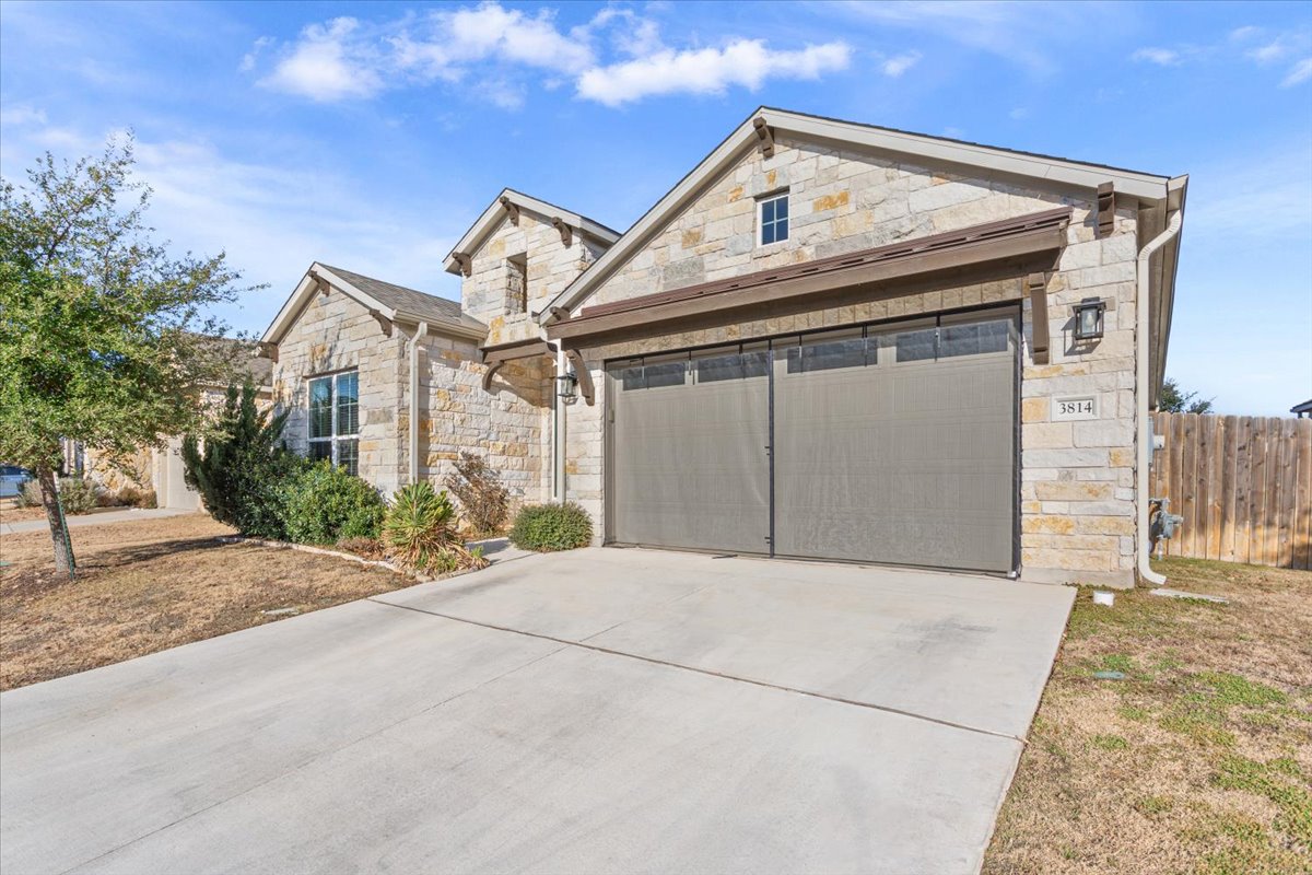 3814 Chance Loop Round Rock, TX 78628 - Photo 2 of 16 View of front of property featuring stone siding, driveway, and an attached garage