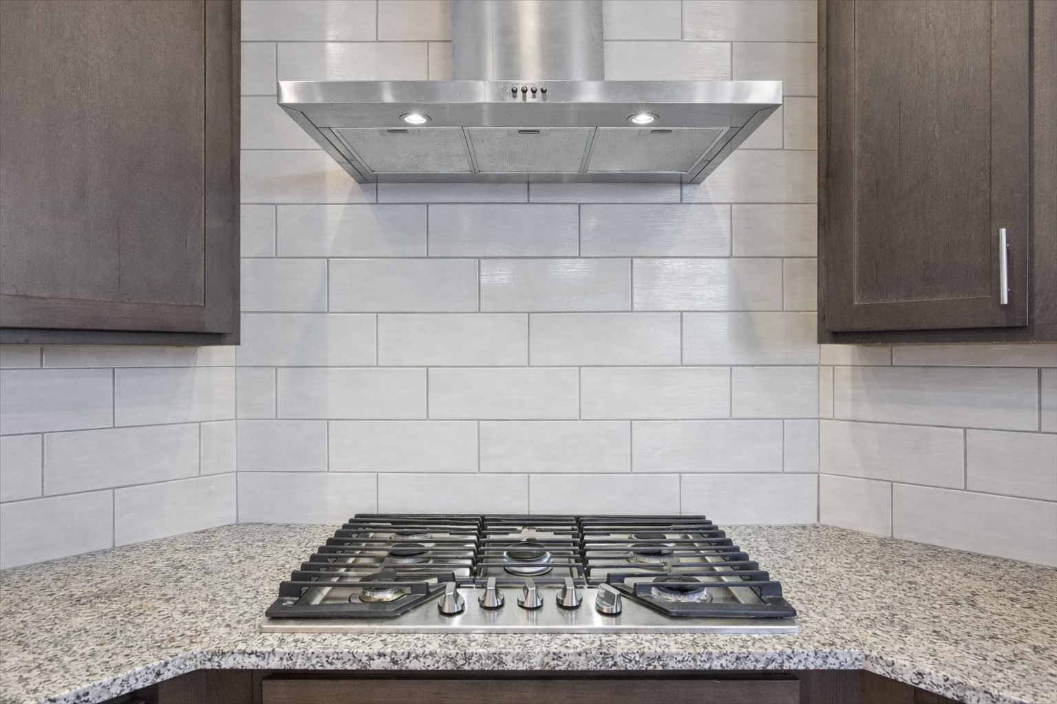 3814 Chance Loop Round Rock, TX 78628 - Photo 5 of 16 Kitchen featuring dark wood finish cabinetry, stainless steel gas stovetop, and light stone countertops