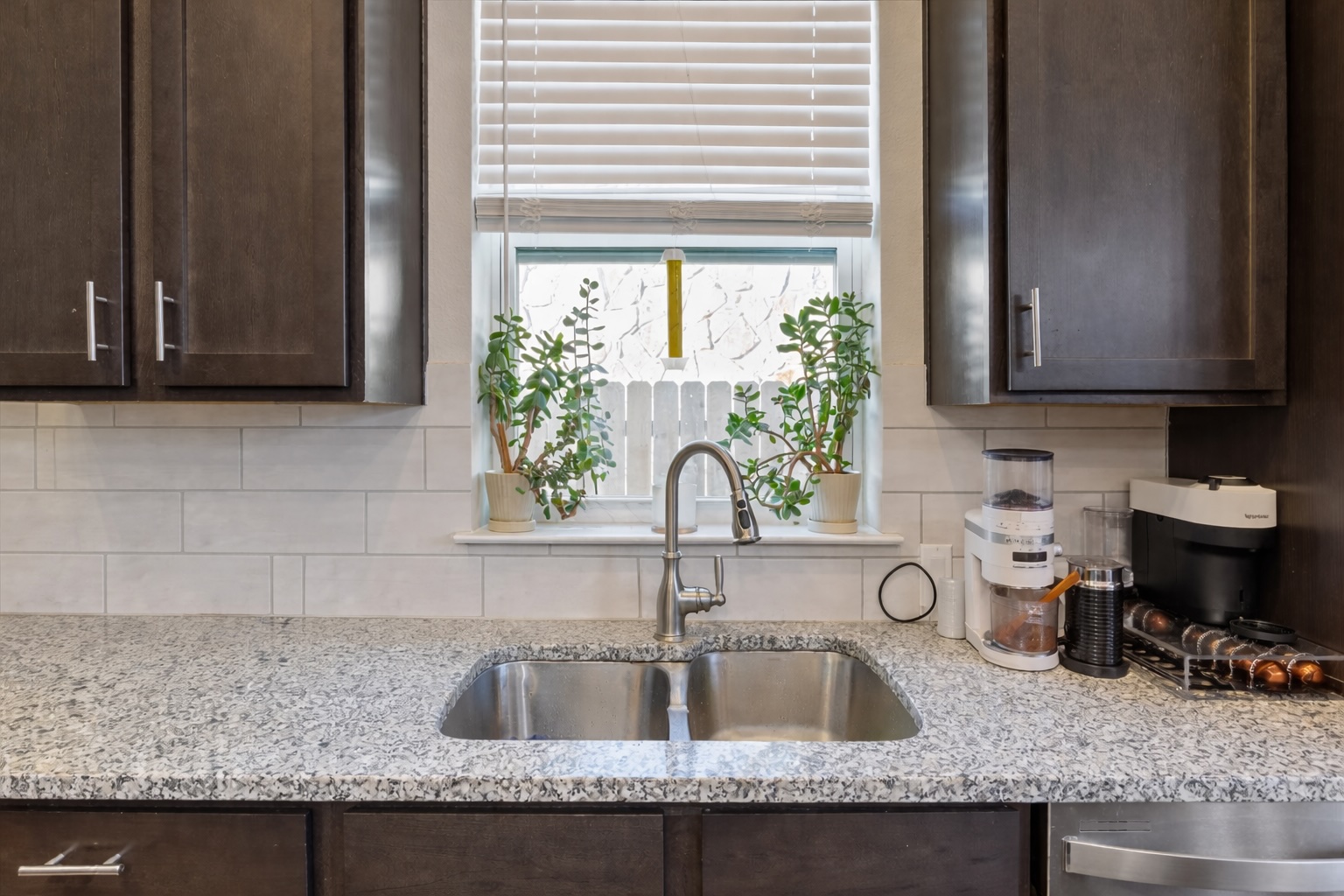3814 Chance Loop Round Rock, TX 78628 - Photo 7 of 16 Kitchen with dark wood finish cabinets, light stone counters, and tasteful backsplash