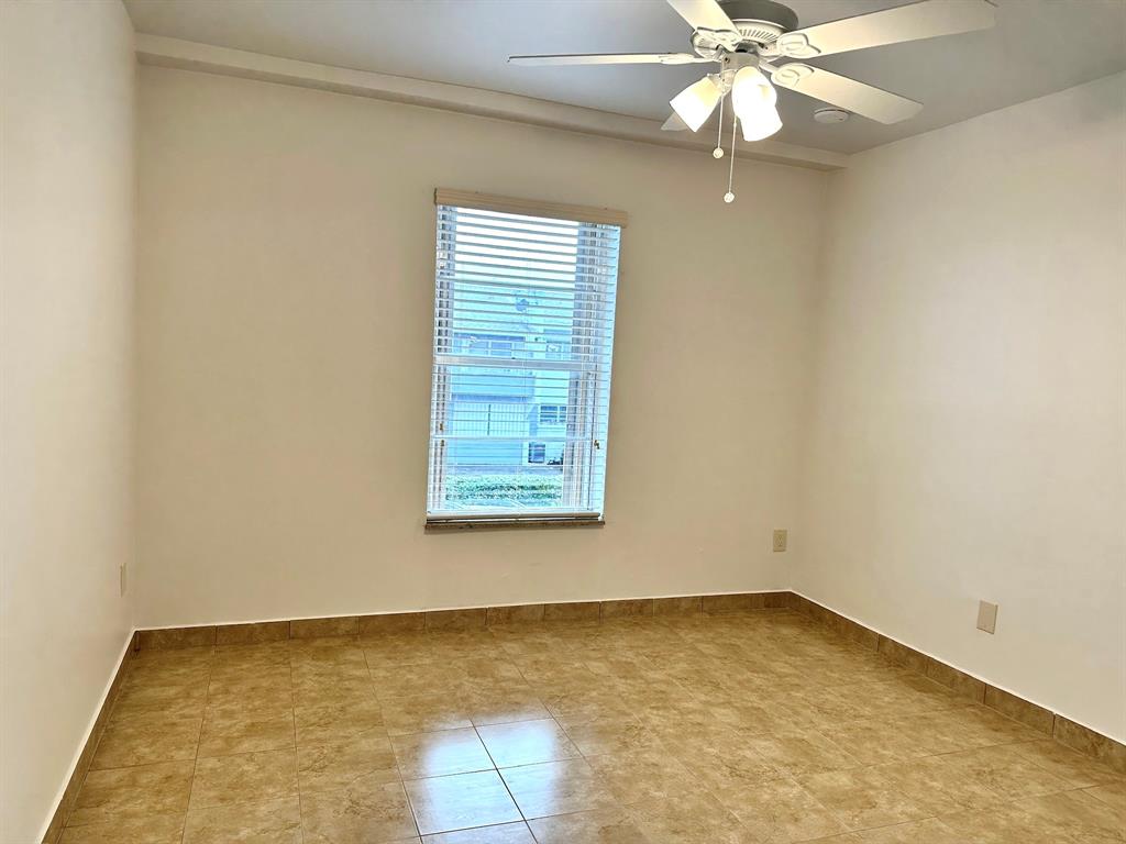 7355 West 4th Avenue, Unit 215 Hialeah, FL 33014 - Photo 12 of 17 an empty room with a window and a fan