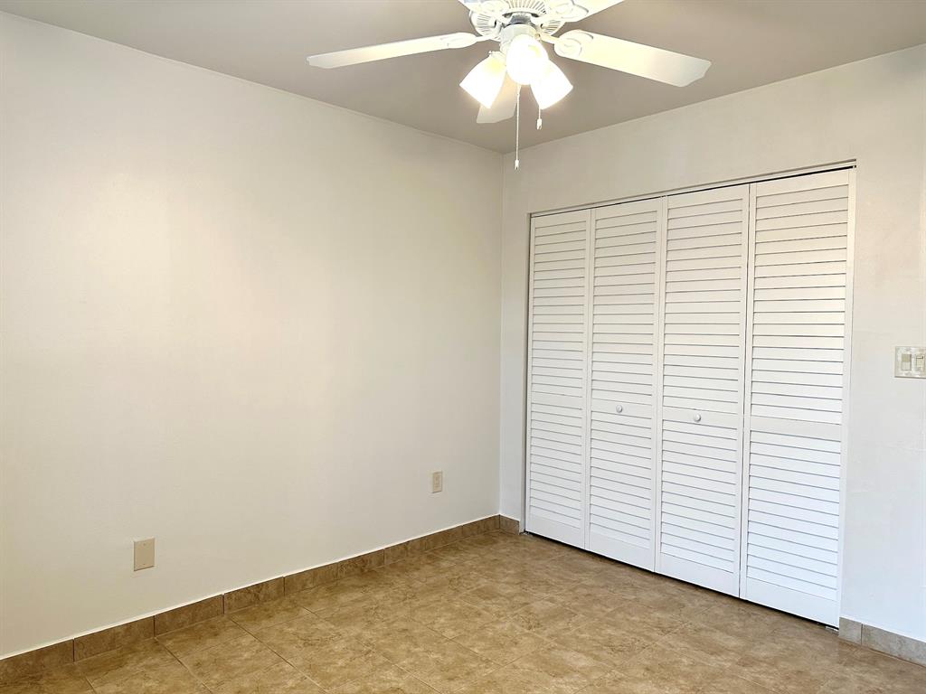 7355 West 4th Avenue, Unit 215 Hialeah, FL 33014 - Photo 13 of 17 an empty room with a ceiling fan and a window