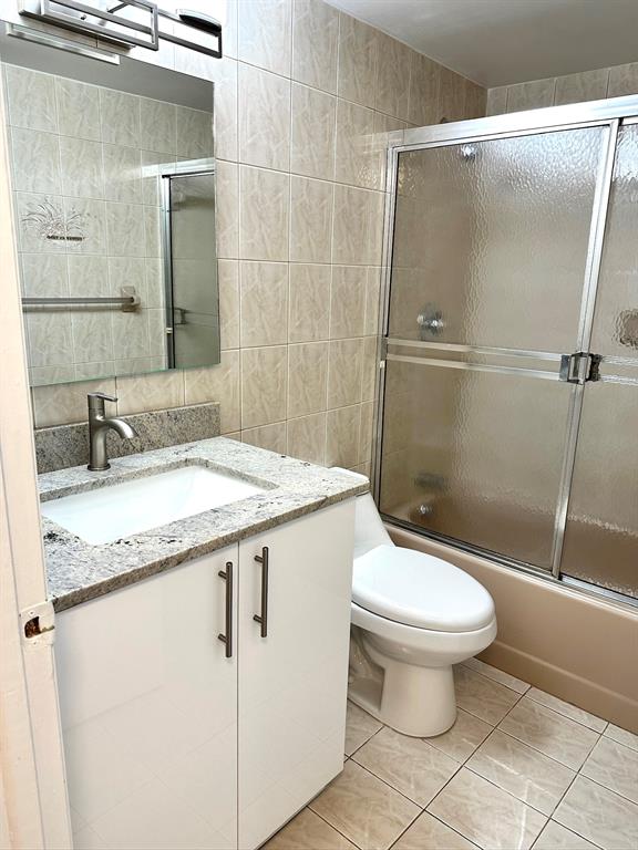 7355 West 4th Avenue, Unit 215 Hialeah, FL 33014 - Photo 14 of 17 a bathroom with a granite countertop sink toilet and a mirror