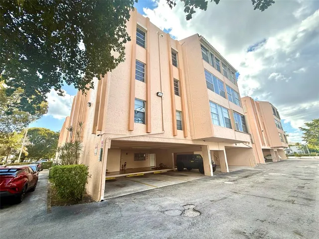 a view of a blue house with a yard and sitting area