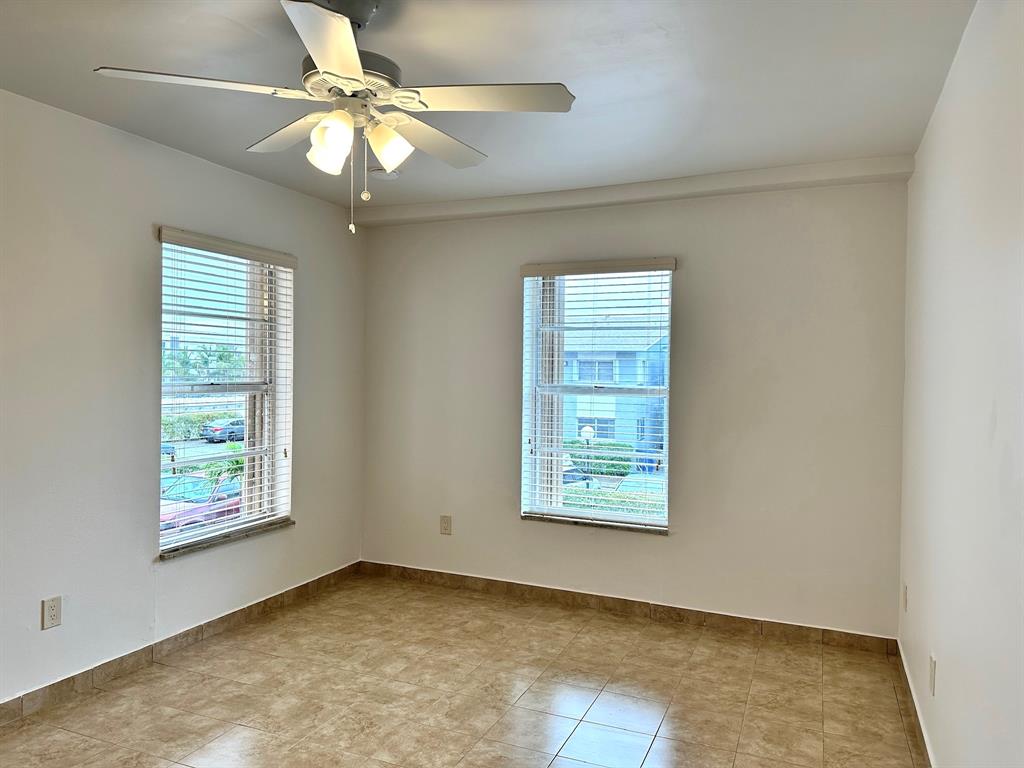 7355 West 4th Avenue, Unit 215 Hialeah, FL 33014 - Photo 7 of 17 an empty room with windows and fan