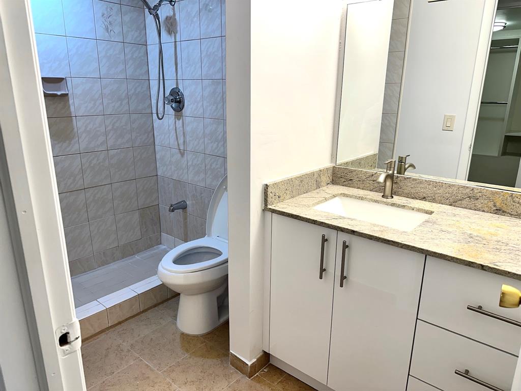 7355 West 4th Avenue, Unit 215 Hialeah, FL 33014 - Photo 9 of 17 a bathroom with a granite countertop sink toilet and shower