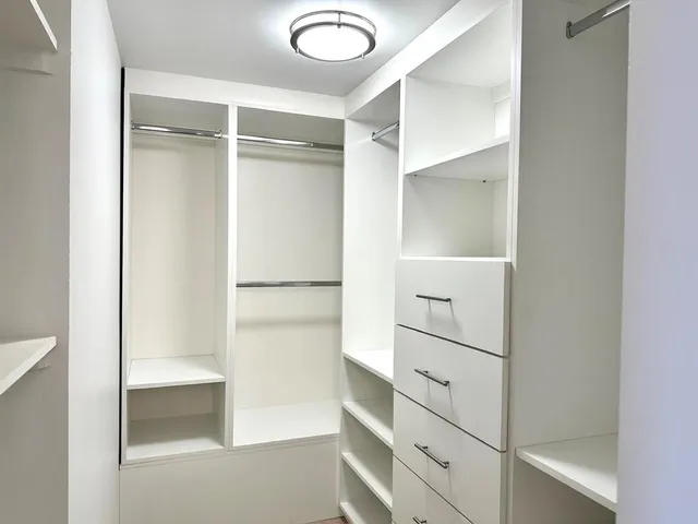 a view of walk in closet with empty racks