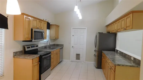 a kitchen with stainless steel appliances granite countertop a stove a sink and a microwave