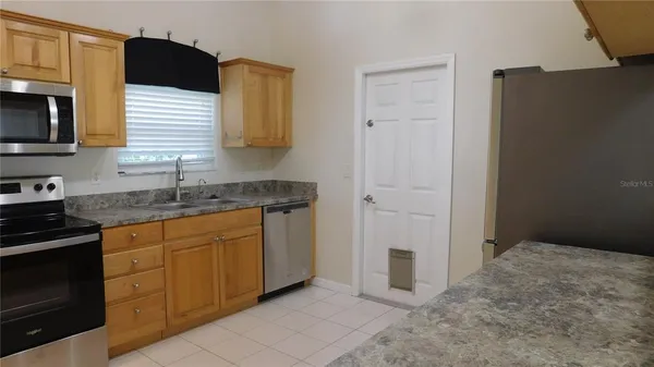 a kitchen with granite countertop cabinets stainless steel appliances and a sink