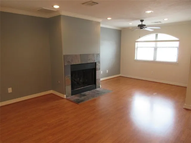 an empty room with windows and fireplace