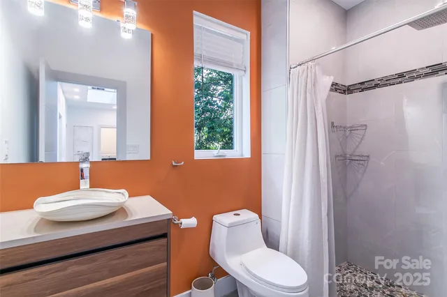 a white toilet sitting next to a shower