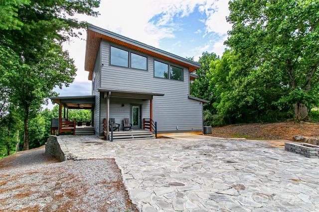 a backyard of a house with plants and outdoor seating