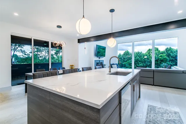 a large kitchen with kitchen island a large window in it