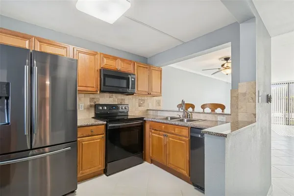 a kitchen with a sink a stove a refrigerator and cabinets