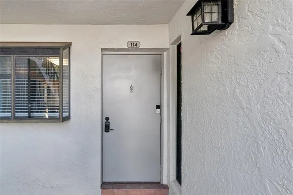 a view of a hallway to a livingroom with wooden floor a sink and windows