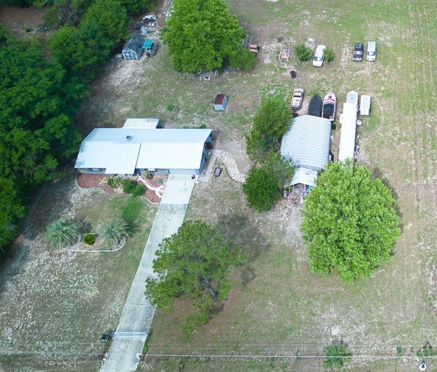 an aerial view of a house with a yard and trees