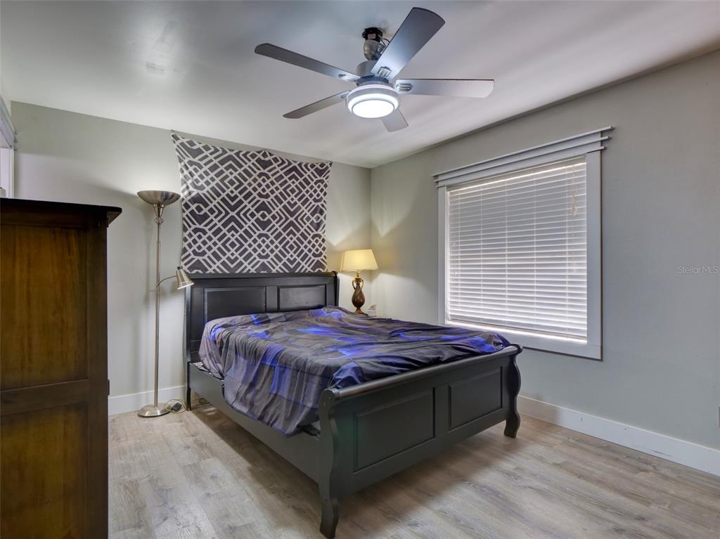 37149 Grays Airport Road Lady Lake, FL 32159 - Photo 11 of 36 a bedroom with a bed chandelier and a window