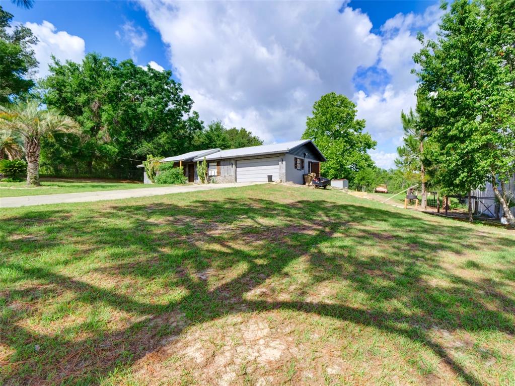 37149 Grays Airport Road Lady Lake, FL 32159 - Photo 21 of 36 a front view of a house with a yard
