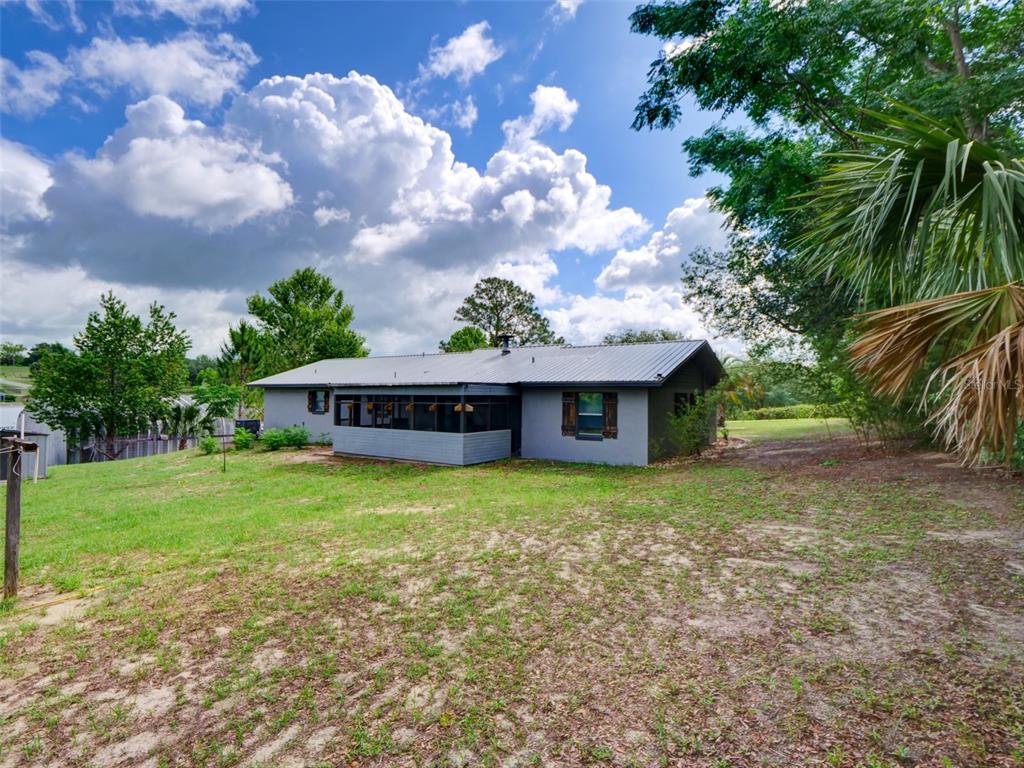 37149 Grays Airport Road Lady Lake, FL 32159 - Photo 25 of 36 a view of a house with a big yard plants and large trees