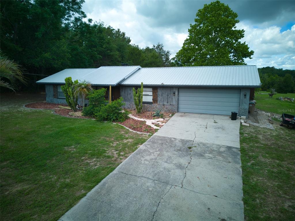 37149 Grays Airport Road Lady Lake, FL 32159 - Photo 36 of 36 a backyard of a house with table and chairs under an umbrella