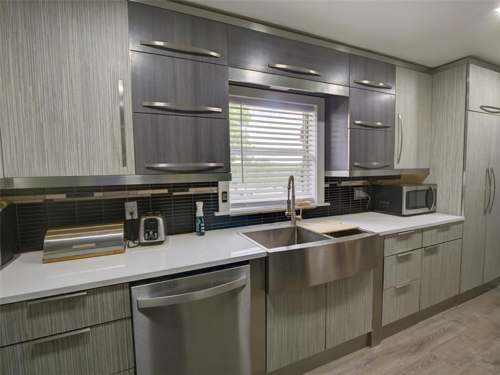 37149 Grays Airport Road Lady Lake, FL 32159 - Photo 8 of 36 a kitchen with stainless steel appliances granite countertop a sink and a microwave