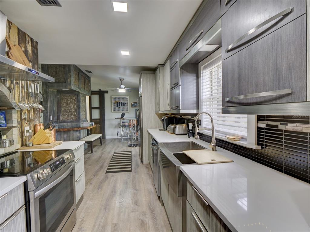 37149 Grays Airport Road Lady Lake, FL 32159 - Photo 9 of 36 a kitchen with counter top space a sink and appliances
