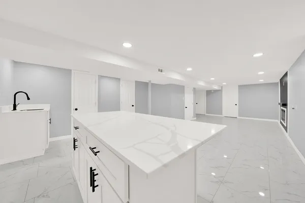 a large white kitchen with a sink a refrigerator and a stove