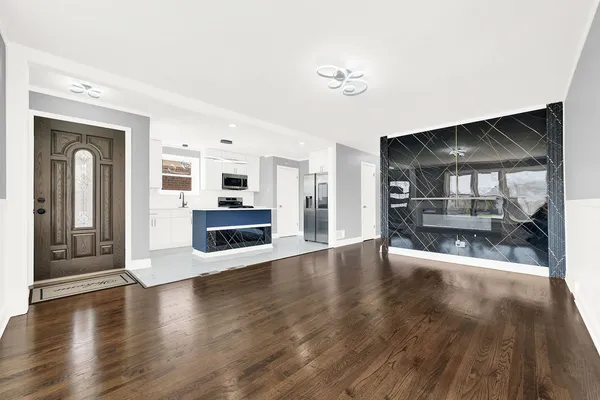a view of a big room with wooden floor fire place and kitchen view