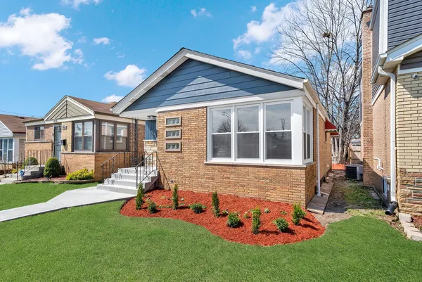 a front view of house with yard and outdoor seating