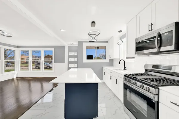 a large kitchen with stainless steel appliances granite countertop a stove and a sink