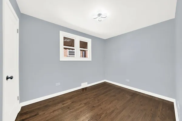 a view of a big room with wooden floor and windows