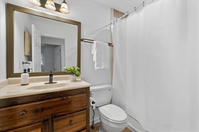a bathroom with a sink vanity mirror and toilet