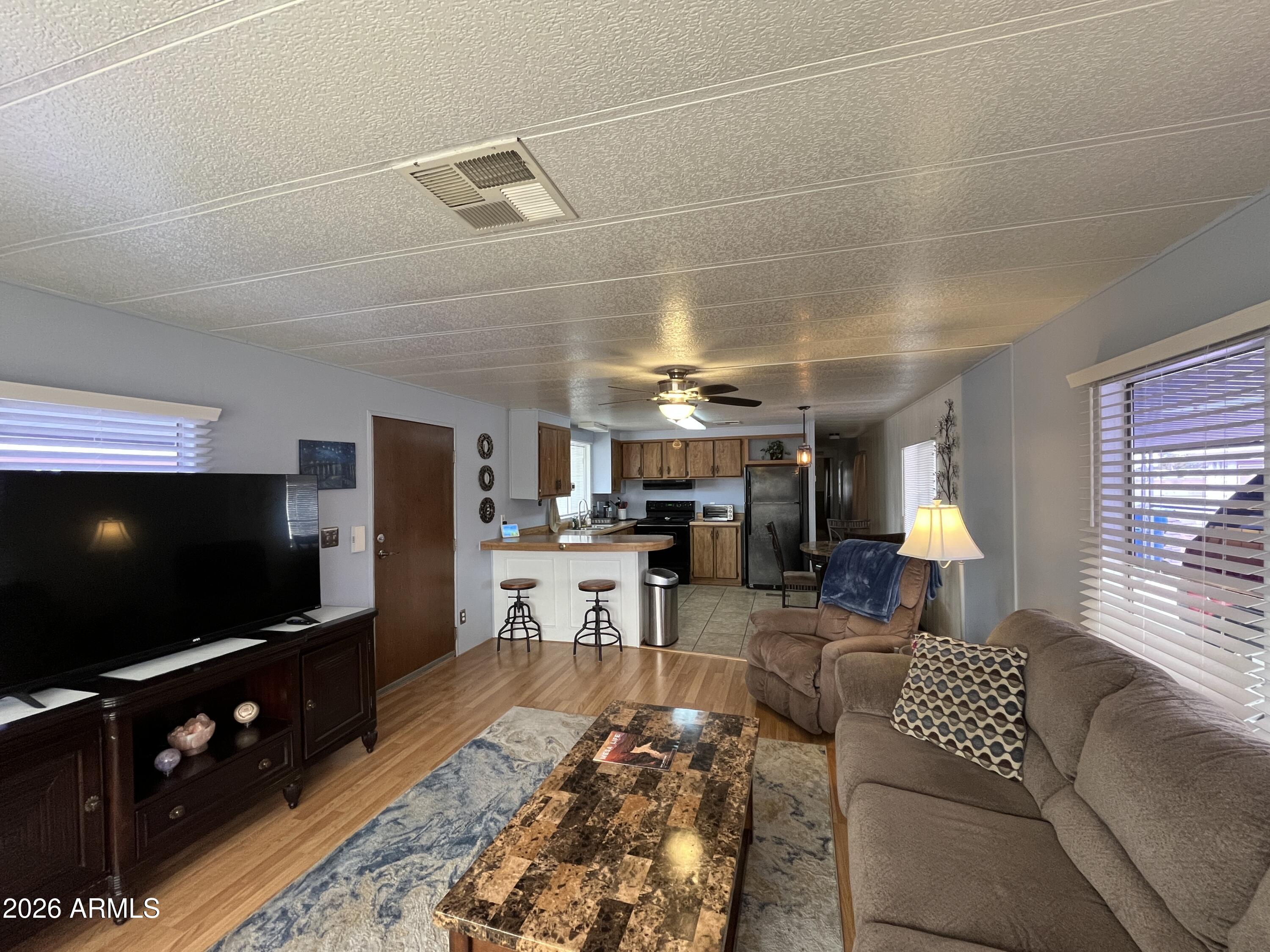 9302 East Broadway Road, Unit 179 Mesa, AZ 85208 - Photo 11 of 54 a living room with furniture and a flat screen tv