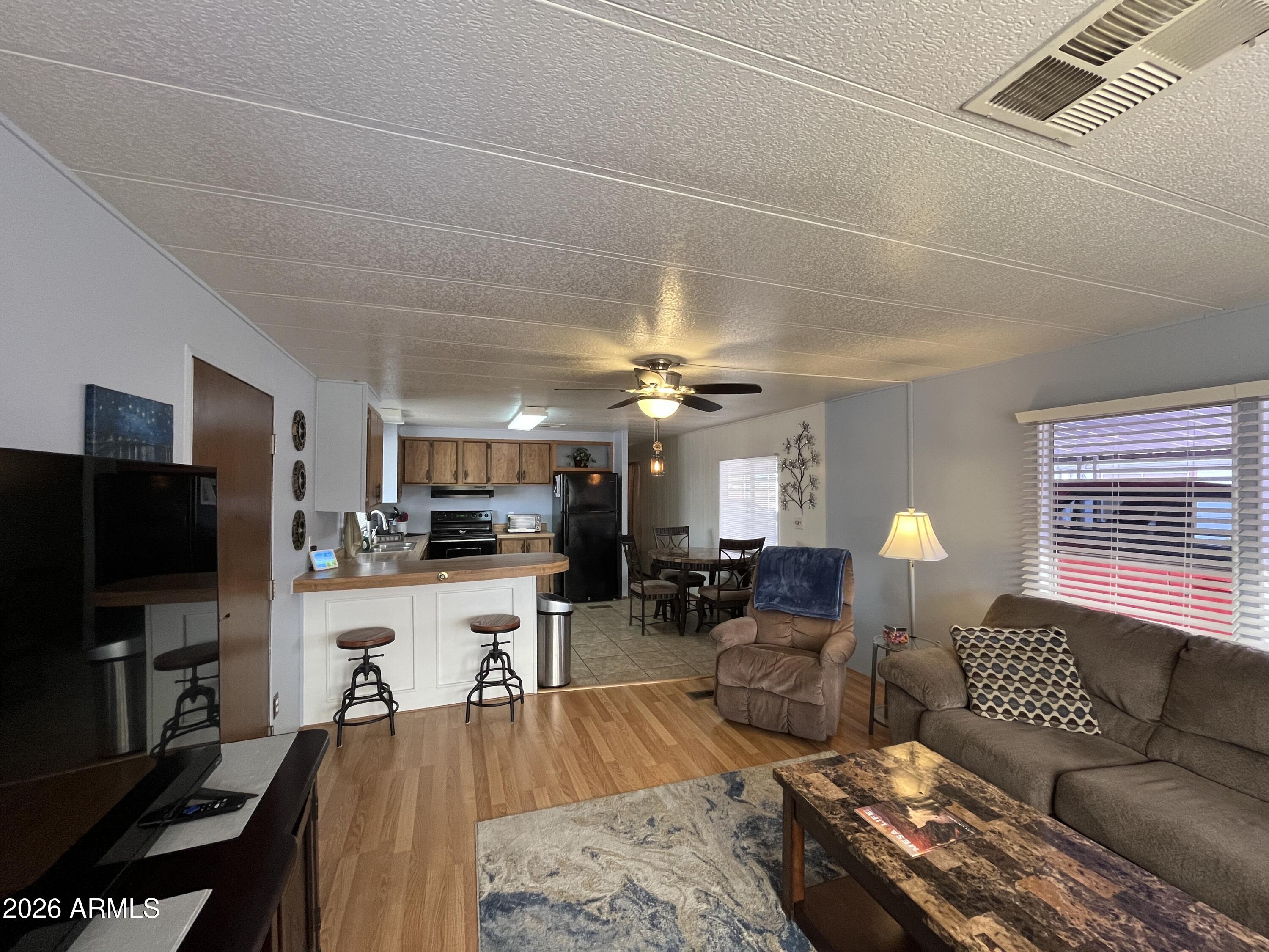 9302 East Broadway Road, Unit 179 Mesa, AZ 85208 - Photo 12 of 54 a living room with furniture and a flat screen tv