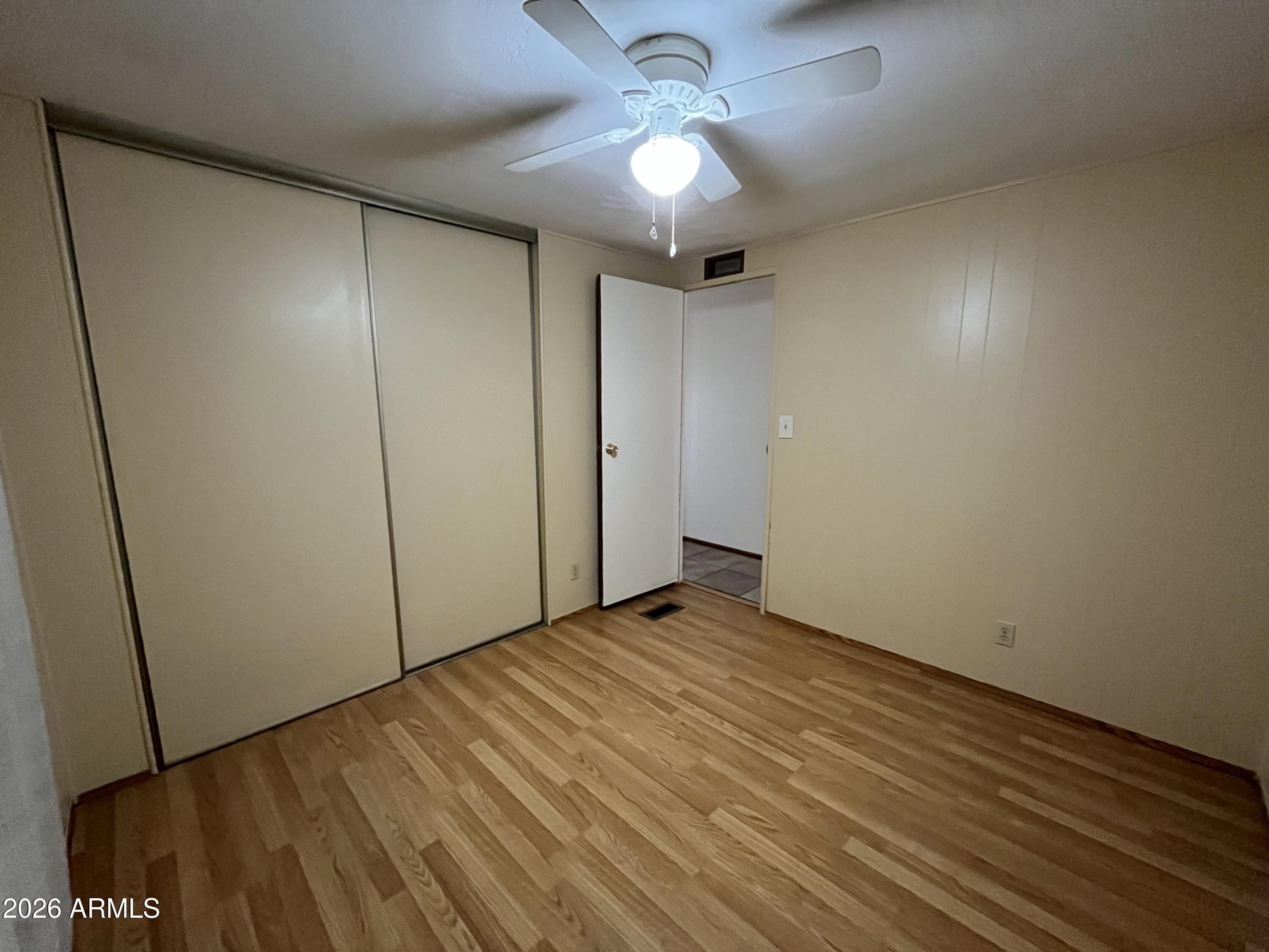 9302 East Broadway Road, Unit 179 Mesa, AZ 85208 - Photo 17 of 54 a view of an empty room with a chandelier fan