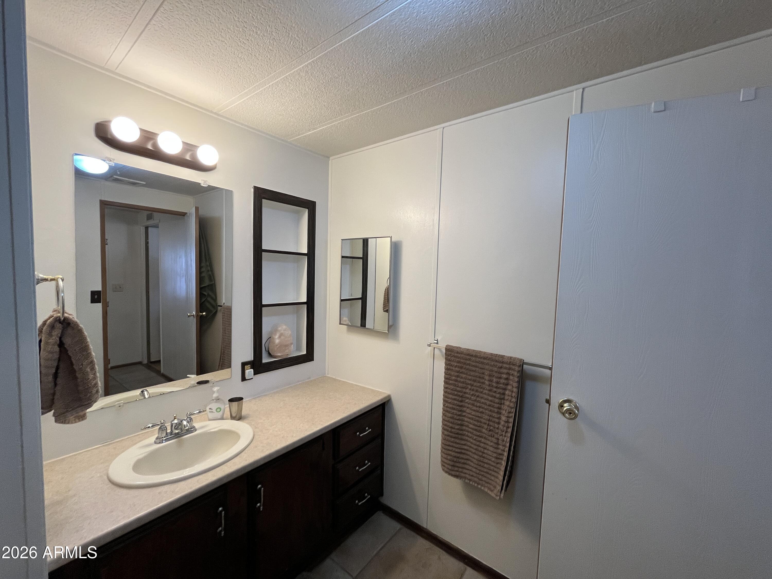 9302 East Broadway Road, Unit 179 Mesa, AZ 85208 - Photo 25 of 54 a bathroom with a double vanity sink and mirror